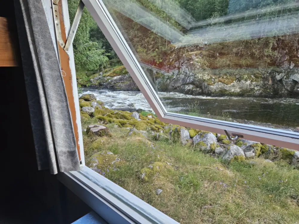 Utsikt mot elva gjennom eit vindauge